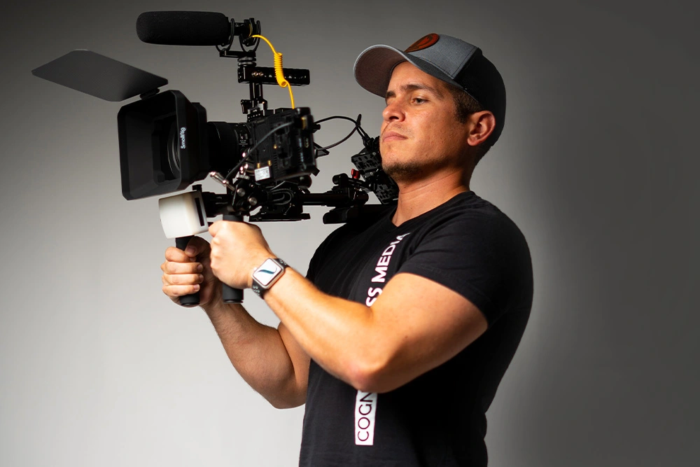 Cesar Gonzalez carrying a professional video camera